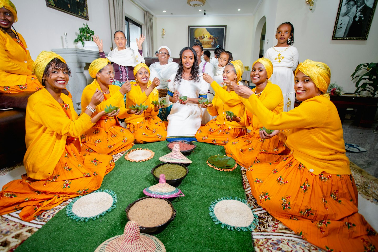 Women and girls gather indoors to prepare traditional grains and powders.