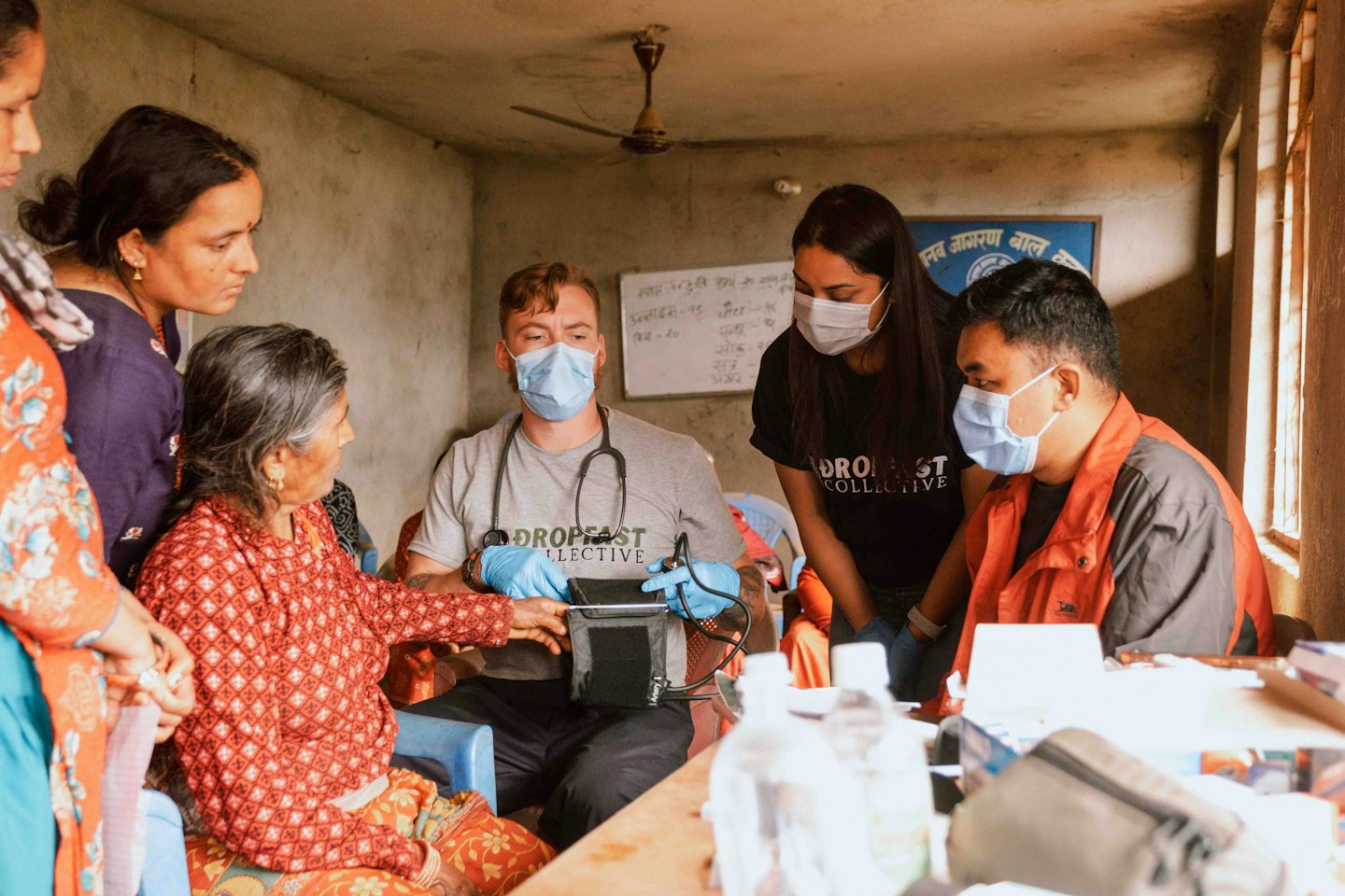 Medical professionals examine an elderly woman during a health checkup.